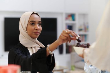 Bir tesettüre bürünmüş genç bir Müslüman kadın, kutsal Ramazan ayında oruç tutmasını simgeleyen tarihleri incelikle alır, ruhani bir yansıma, kültürel gelenek ve