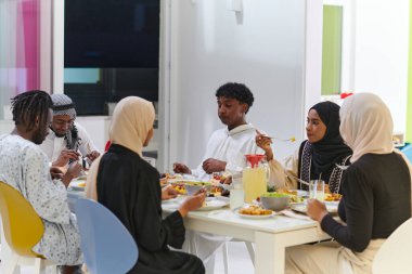 Geleneksel ve çeşitli Müslüman bir aile kutsal Ramazan ayında, aile neşesi, kültürel zenginlik ve ruhsal birliğin özünü somutlaştıran lezzetli bir iftar yemeğini paylaşmak için bir araya geliyor.