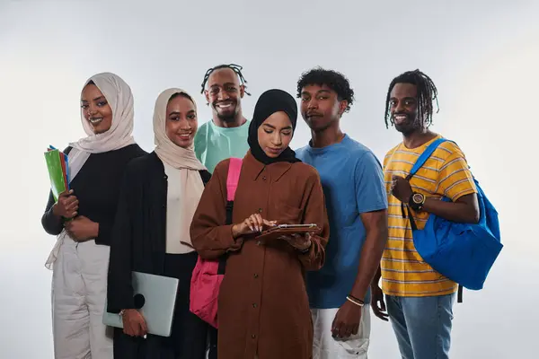 stock image Group of diverse students engages in modern educational practices, utilizing a variety of technological tools such as laptops, tablets, and smartphones against a clean white background, exemplifying