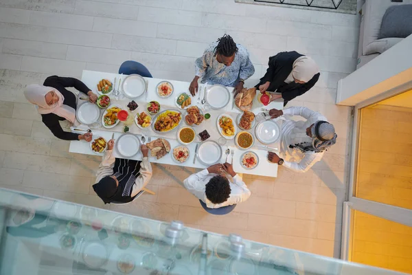 Top view of a Muslim family joyously comes together around a table, eagerly awaiting the communal iftar, engaging in the preparation of a shared meal, and uniting in anticipation of a collective