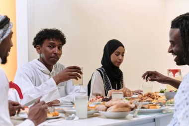 Geleneksel ve çeşitli Müslüman bir aile kutsal Ramazan ayında, aile neşesi, kültürel zenginlik ve ruhsal birliğin özünü somutlaştıran lezzetli bir iftar yemeğini paylaşmak için bir araya geliyor.