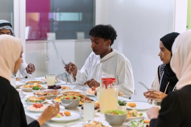 Geleneksel ve çeşitli Müslüman bir aile kutsal Ramazan ayında, aile neşesi, kültürel zenginlik ve ruhsal birliğin özünü somutlaştıran lezzetli bir iftar yemeğini paylaşmak için bir araya geliyor.