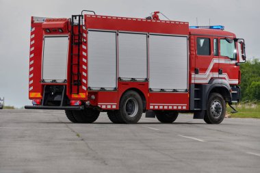 Bu büyüleyici sahnede, gelişmiş kurtarma teknolojisiyle donatılmış gelişmiş bir itfaiye aracı, müdahale etmeye ve hızlı bir şekilde karşılık vermeye hazır olan yetenekli itfaiye ekibiyle birlikte beklemektedir.
