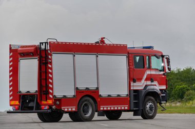 Bu büyüleyici sahnede, gelişmiş kurtarma teknolojisiyle donatılmış gelişmiş bir itfaiye aracı, müdahale etmeye ve hızlı bir şekilde karşılık vermeye hazır olan yetenekli itfaiye ekibiyle birlikte beklemektedir.