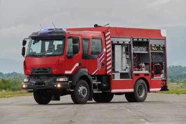 Bu büyüleyici sahnede, gelişmiş kurtarma teknolojisiyle donatılmış gelişmiş bir itfaiye aracı, müdahale etmeye ve hızlı bir şekilde karşılık vermeye hazır olan yetenekli itfaiye ekibiyle birlikte beklemektedir.