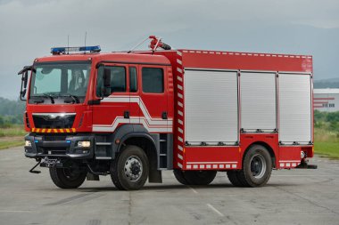 Bu büyüleyici sahnede, gelişmiş kurtarma teknolojisiyle donatılmış gelişmiş bir itfaiye aracı, müdahale etmeye ve hızlı bir şekilde karşılık vermeye hazır olan yetenekli itfaiye ekibiyle birlikte beklemektedir.