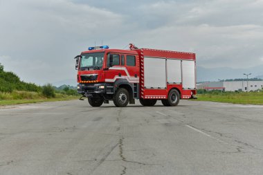 Bu büyüleyici sahnede, gelişmiş kurtarma teknolojisiyle donatılmış gelişmiş bir itfaiye aracı, müdahale etmeye ve hızlı bir şekilde karşılık vermeye hazır olan yetenekli itfaiye ekibiyle birlikte beklemektedir.