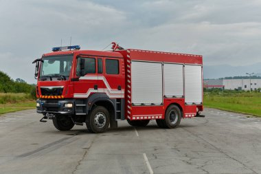 Bu büyüleyici sahnede, gelişmiş kurtarma teknolojisiyle donatılmış gelişmiş bir itfaiye aracı, müdahale etmeye ve hızlı bir şekilde karşılık vermeye hazır olan yetenekli itfaiye ekibiyle birlikte beklemektedir.