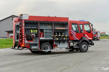 Bu büyüleyici sahnede, gelişmiş kurtarma teknolojisiyle donatılmış gelişmiş bir itfaiye aracı, müdahale etmeye ve hızlı bir şekilde karşılık vermeye hazır olan yetenekli itfaiye ekibiyle birlikte beklemektedir.