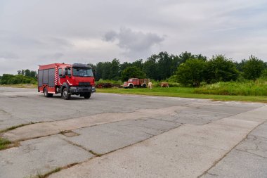 Bu büyüleyici sahnede, gelişmiş kurtarma teknolojisiyle donatılmış gelişmiş bir itfaiye aracı, müdahale etmeye ve hızlı bir şekilde karşılık vermeye hazır olan yetenekli itfaiye ekibiyle birlikte beklemektedir.