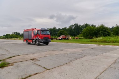 Bu büyüleyici sahnede, gelişmiş kurtarma teknolojisiyle donatılmış gelişmiş bir itfaiye aracı, müdahale etmeye ve hızlı bir şekilde karşılık vermeye hazır olan yetenekli itfaiye ekibiyle birlikte beklemektedir.