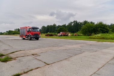 Bu büyüleyici sahnede, gelişmiş kurtarma teknolojisiyle donatılmış gelişmiş bir itfaiye aracı, müdahale etmeye ve hızlı bir şekilde karşılık vermeye hazır olan yetenekli itfaiye ekibiyle birlikte beklemektedir.