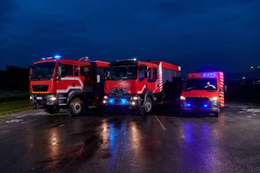 Bir çift son derece modern ve kaliteli itfaiye kamyonu geceyi dönen ışıklarıyla aydınlatıyor, son teknolojiyi ve itfaiyeci filosunun hazırlığını simgeliyor, karşılık vermeye hazır.