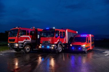 Bir çift son derece modern ve kaliteli itfaiye kamyonu geceyi dönen ışıklarıyla aydınlatıyor, son teknolojiyi ve itfaiyeci filosunun hazırlığını simgeliyor, karşılık vermeye hazır.