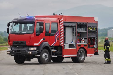 İtfaiyeci titizlikle modern bir itfaiye aracını tehlikeli durumlara müdahale ve boşaltma görevi için hazırlıyor. Yangına karşı güvenlik ve hazır olma azmini gösteriyor.