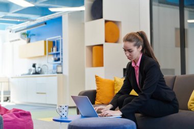 Akıllı telefon kullanan meşgul bir iş kadını. Modern bir açık uzay ofis işyerinde tek başına mutlu genç bir iş kadını. Ofiste müşterileriyle iletişim kuran bir iş kadını.. 