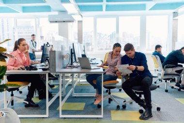 Ofiste yapılan beyin fırtınası sırasında çok kültürlü genç iş adamlarının ortak çalışma süreci. Resmi olarak giyinmiş çeşitli gençler tasarım projesinin geliştirilmesinde işbirliği yapıyor.