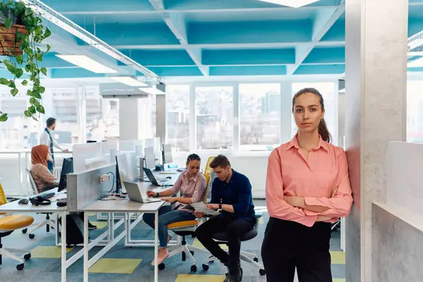 創造的なオープンスペースのコワーキングスタートアップオフィスでの若い笑顔のビジネス女性の肖像 コピースペース付きオフィスに立つ成功した実業家 バックグラウンドで働く労働者 — ストック写真