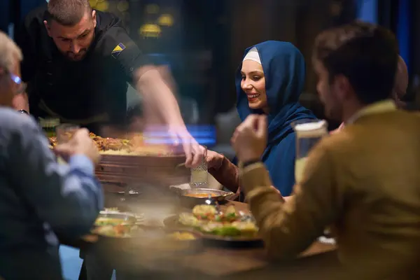 心温まるシーンでは プロのシェフがヨーロッパのイスラム教徒の家族にラマダンの神聖な月の間に彼らのイフタール料理を提供し 共有の瞬間に文化的な団結と料理のホスピタリティを体現しています — ストック写真