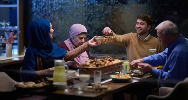 モダンで伝統的なヨーロッパのイスラムファミリーは ラマダン断食期間中に現代的なレストランでイタールのために集まり 文化的な調和と家族の団結を体現しています — ストック写真
