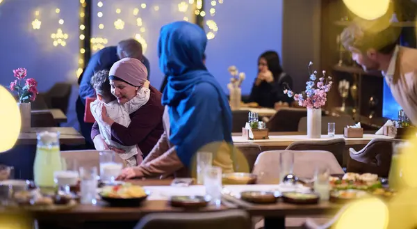 祖父母は ラマダンの神聖な月の間にレストランでイフタールのために集う子供たちと孫たちに到着し 贈り物を受け取り 団結の大切な瞬間を分かち合います — ストック写真