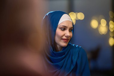 Modern bir restoranda, güzel Avrupalı Müslüman bir kadın kutsal Ramazan ayı boyunca zarafet ve ruhani huzuru somutlaştıran ortam ve yemek zevklerinin tadını çıkarıyor.