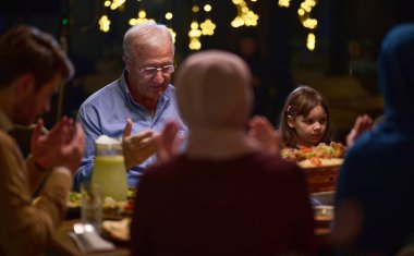 Modern bir restoran ortamında, Avrupalı bir İslami aile iftar için Ramazan ayında bir araya gelir, yemekten önce dua eder, gelenek ve çağdaş uygulamaları bir kutlama için birleştirir.