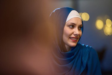 Modern bir restoranda, güzel Avrupalı Müslüman bir kadın kutsal Ramazan ayı boyunca zarafet ve ruhani huzuru somutlaştıran ortam ve yemek zevklerinin tadını çıkarıyor.