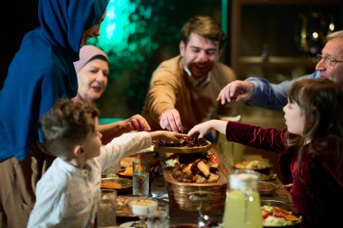 Bu modern tasvirde, Avrupalı bir İslami aile Ramazan 'da oruç tutma geleneğini tarihlerle, birlik, kültür mirası ve kutsal dönemin ruhani değerlerini sembolize ederek bozuyor.