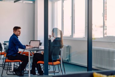 Takım elbiseli bir iş lideri, bilişim sektöründeki çalışanıyla yeni iş projeleri ve mevcut iş sorunları hakkında konuşuyor.. 