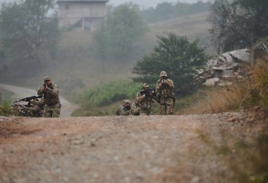 Disiplinli ve özel bir askeri birlik, kamuflajlı, stratejik devriye gezen ve yüksek bahisli bir ortamda kontrolü elinde tutan, hassasiyetlerini, birliklerini ve hazırlıklarını gösteren