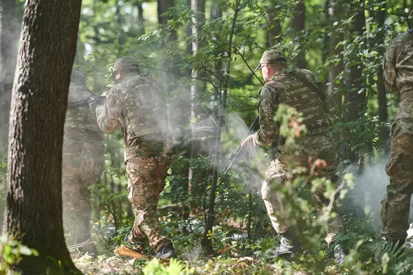 stock image A specialized military antiterrorist unit conducts a covert operation in dense, hazardous woodland, demonstrating precision, discipline, and strategic readiness. 