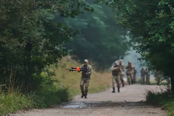 精锐的军事单位在森林中巡游和保卫 使用无人驾驶飞机进行地形扫描和侦察 展示他们在高风险行动中的先进技能和专门训练 — 图库照片