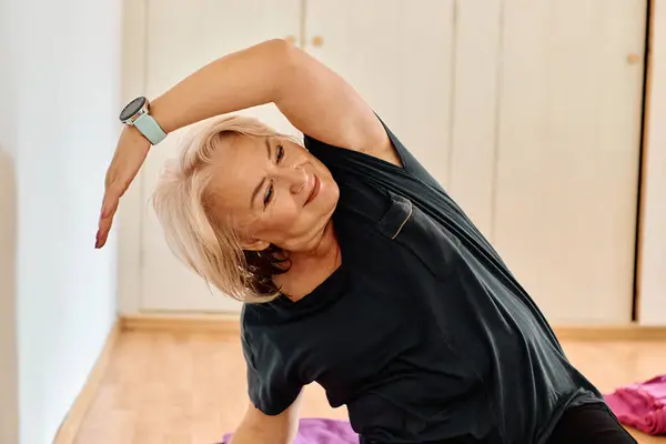 在阳光普照的空间里 一位老妇人优雅地练习恢复瑜伽的活力 专注于脖子 背和腿的伸展 体现了宁静和幸福 — 图库照片