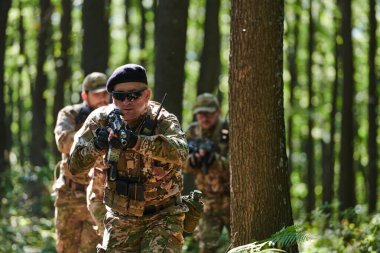 Uzman bir askeri anti-terör birimi yoğun, tehlikeli ormanlık alanda hassas, disiplinli ve stratejik olarak hazır olduğunu gösteren gizli bir operasyon yürütüyor..