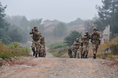 Disiplinli ve özel bir askeri birlik, kamuflajlı, stratejik devriye gezen ve yüksek bahisli bir ortamda kontrolü elinde tutan, hassasiyetlerini, birliklerini ve hazırlıklarını gösteren