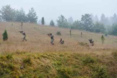 Disiplinli ve özel bir askeri birlik, kamuflajlı, stratejik devriye gezen ve yüksek bahisli bir ortamda kontrolü elinde tutan, hassasiyetlerini, birliklerini ve hazırlıklarını gösteren