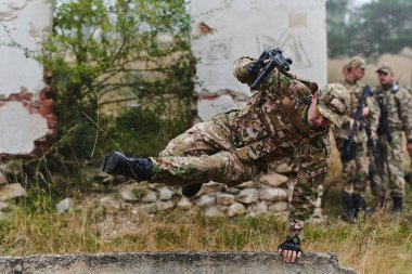 İyi eğitimli, kamuflajlı seçkin bir askeri birlik tehlikeli orman arazisinde ustalıkla yol alır, engelleri aşar ve kusursuz ve gizli bir görevi yerine getirir.. 