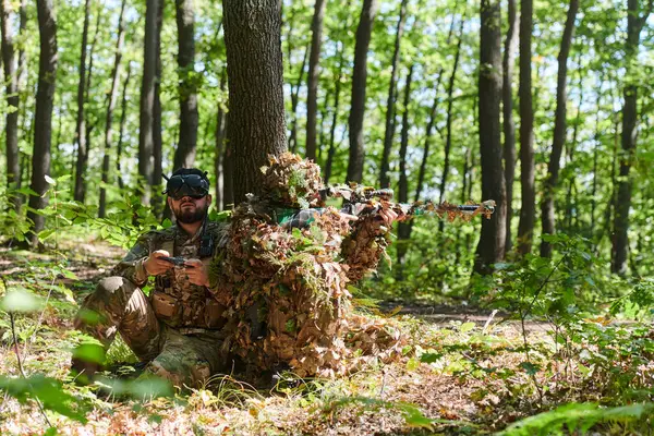 Vrゴーグルでドローンを操作する熟練したスナイパーと兵士は 森に隠れている間に軍事行動を戦略化し 観察します — ストック写真