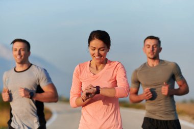 Bir grup arkadaş, sporcu ve koşucu sabahın erken saatlerinde güneşin doğuşuyla enerji dolu ve doğanın sakin güzelliğiyle çevrelenmiş bir şekilde puslu şafakta koşarken kucaklaşıyorlar.. 