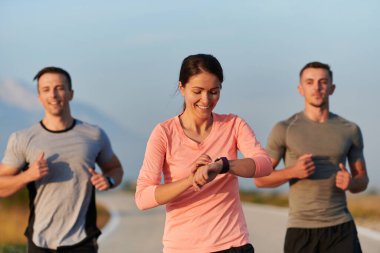 Bir grup arkadaş, sporcu ve koşucu sabahın erken saatlerinde güneşin doğuşuyla enerji dolu ve doğanın sakin güzelliğiyle çevrelenmiş bir şekilde puslu şafakta koşarken kucaklaşıyorlar.. 