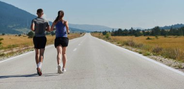 Açık havada koşan canlı bir çift atletizm ve romantizmin özünü somutlaştırıyor. Kendine güvenen adımları gelecekteki maratona ortak bir bağlılığı ve hazırlığı yansıtıyor.