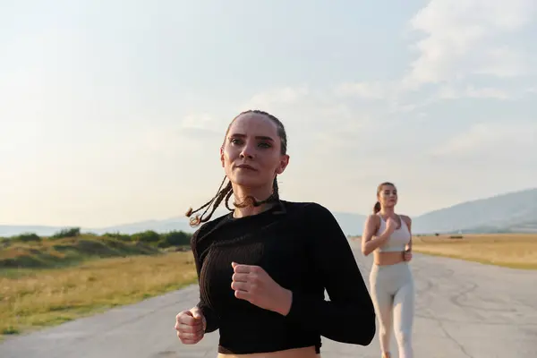 Stock image On a beautiful sunny day, two athletic friends enjoy a run together, maintaining their healthy lifestyle and fitness regimen.