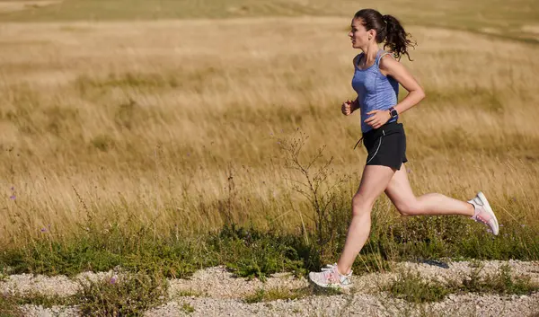一位孤独的跑步者精力充沛地追求她的健身目标 准备迎接即将到来的马拉松挑战 同时拥抱健康的生活方式 这体现了她的力量和决心 — 图库照片