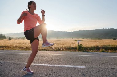 Kararlı bir atletik kadın koşudan sonra esneme hareketleri yapar, spor yolculuğuna kendini adamaya ve vücudunun esnekliğini ve esnekliğini arttırmaya çalışır.