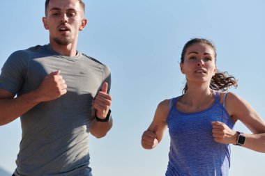 Bir çift güneş lekeli bir yolda koşar, vücutları güçlü ve sağlıklıdır, birbirlerine olan sevgileri ve her adımda aşikardır.. 