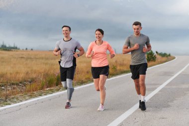 Bir grup arkadaş, sporcu ve koşucu sabahın erken saatlerinde güneşin doğuşuyla enerji dolu ve doğanın sakin güzelliğiyle çevrelenmiş bir şekilde puslu şafakta koşarken kucaklaşıyorlar.. 