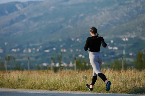 一位女运动员在日出时穿过一条美丽的小径 在健康的生活方式中找到了自由和快乐 — 图库照片