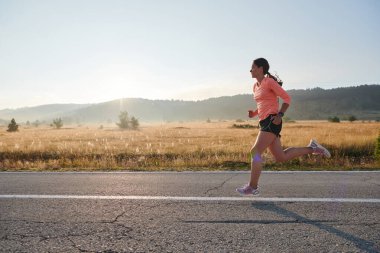 Kararlı ve motive olmuş bir sporcu gün doğumuna güvenle koşuyor, sabah koşusunda kararlılığını ve gücünü özetliyor.. 