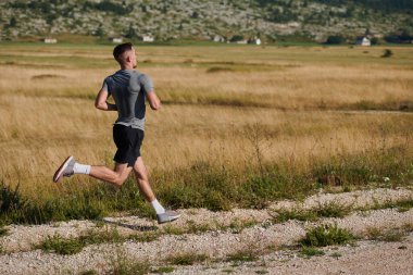 Atletik bir adam koşarken kararlılığını sergiler, sağlıklı bir yaşam tarzına ve yaklaşan maraton yarışmasına hazırlanmaya bağlıdır.